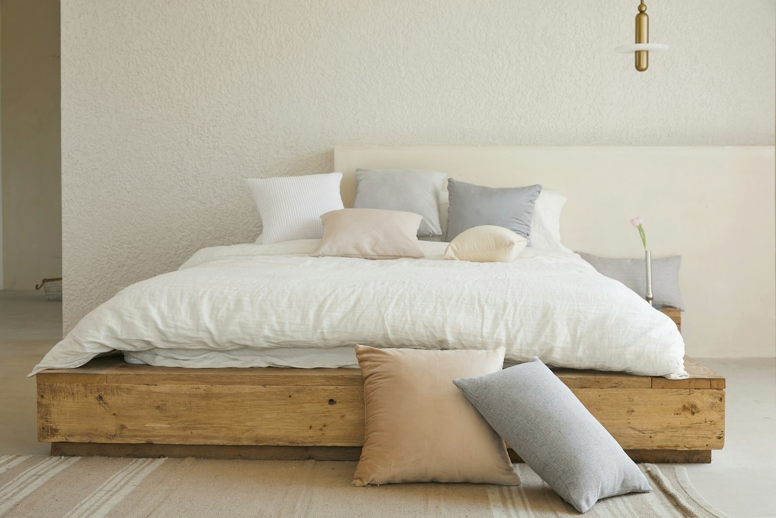 Raw oak bed against plaster wall
