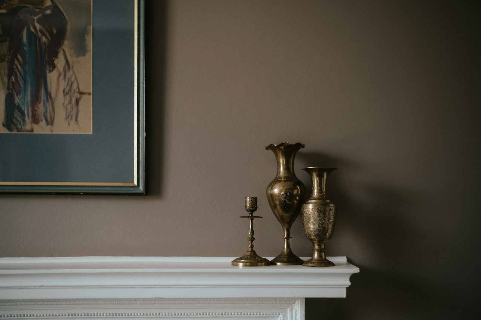 Brass vases on white mantel