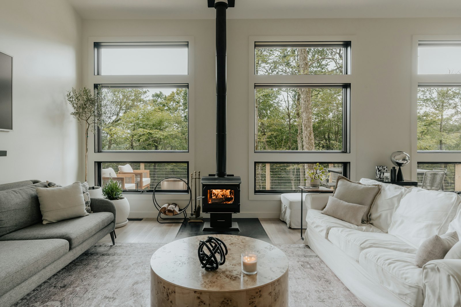 Cabin living room with wood stove and tall windows