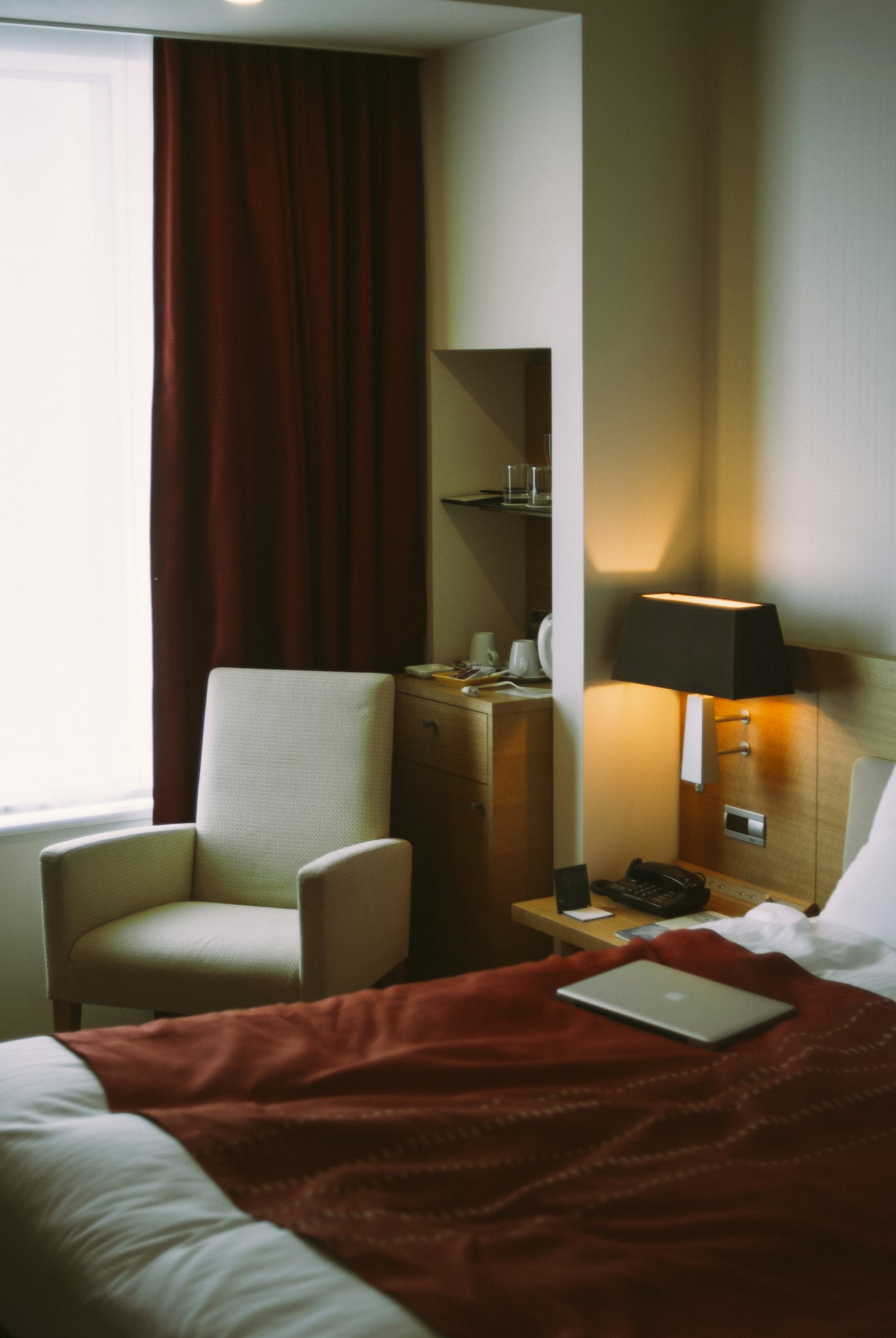Warm hotel suite with curtains and reading chair